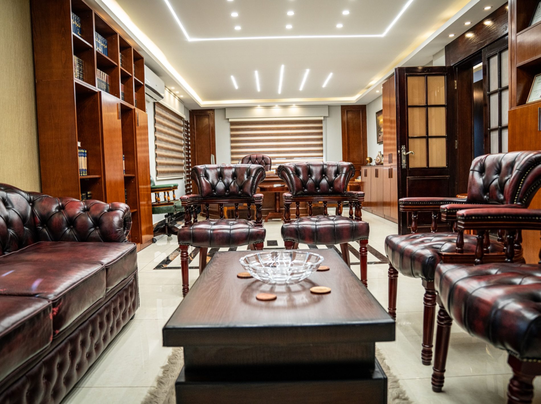 The firm's meeting room, with oxblood leather seating and a wall of law reports.